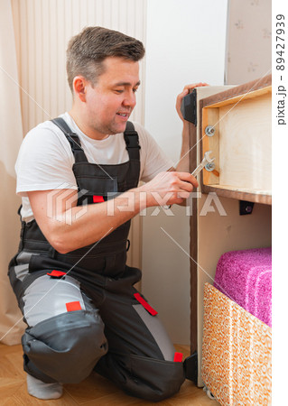 a man assembles furniture. carpenter and handyman services a man assembles furniture. carpenter and handyman services 89427939