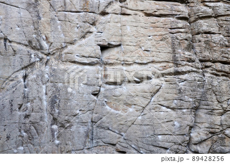 Light coarse natural rock stone background. Mining cliff rough front surface. Big limestone stack backdrop. Heavy grunge damaged granite block texture Light coarse natural rock stone background. Mining cliff rough front surface. Big limestone stack backdrop. Heavy grunge damaged granite block texture 89428256