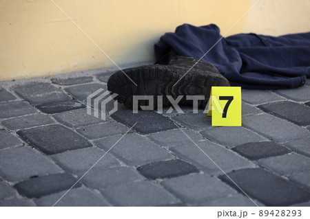 Evidence with yellow CSI marker for evidence numbering on the residental backyard in evening. Crime scene investigation concept 89428293