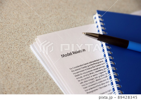 Model release blank form with blue notepad and blue pen lies on photographers table. Model release signing photo 89428345