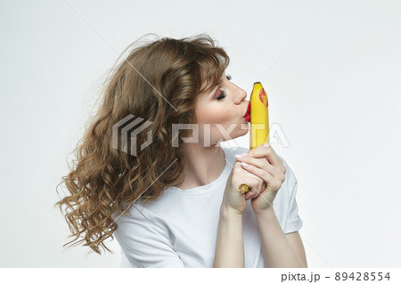 attractive girl kisses a banana and leaves a trace of a kiss with red lipstick attractive girl kisses a banana and leaves a trace of a kiss with red lipstick 89428554