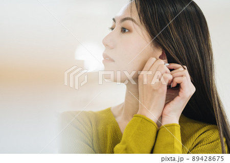 アクセサリーをつける女性 89428675
