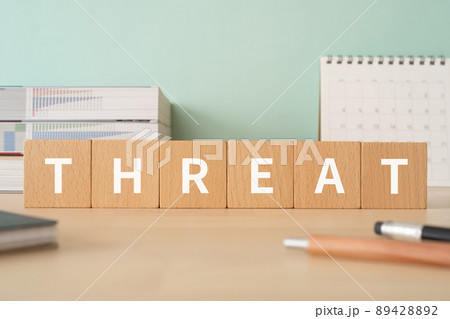 脅し・脅迫のイメージ｜「THREAT」と書かれた積み木が置かれたデスク 89428892