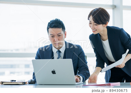 女性スタッフから業務内容の説明を受けるマネージャー 女性スタッフから業務内容の説明を受けるマネージャー 89430675