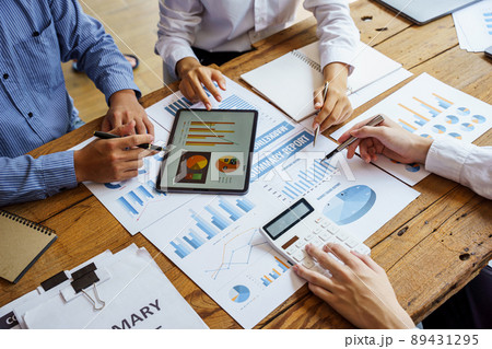 Team work discussing in valuation data in meeting room, three business people with accounting paper charts. Team work discussing in valuation data in meeting room, three business people with accounting paper charts. 89431295