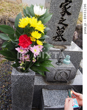 墓参りで線香に火を灯すところ 89431296