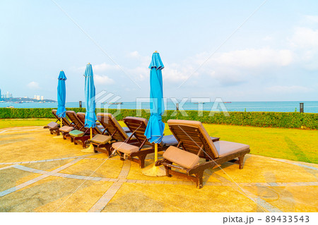 chair pool and umbrella around swimming pool 89433543