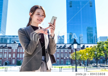 東京丸の内でスマホを操作する若いビジネスウーマン 89433808