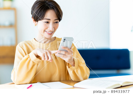 自宅学習中にスマホを使うミドルの女性 89433977