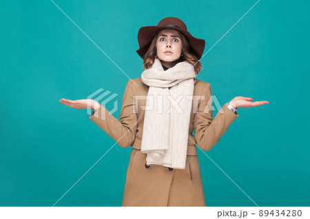 Hmm, i don't know. Confusion and pondering cute woman looking at camera. Indoor shot 89434280
