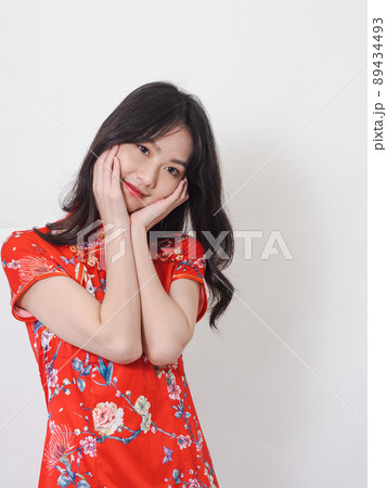 Portrait of young asian woman wearing traditional cheongsam qipao dress touch face on white background. 89434493