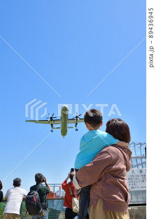 飛行機の着陸を見上げる親子 89436945