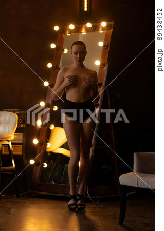 Alluring woman covering breast in studio 89438452