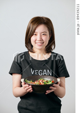 サラダボウルを持って微笑む若いヴィーガン女性 89439211