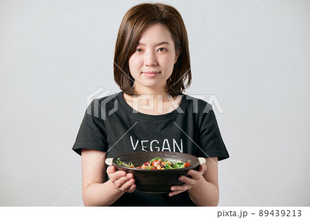 サラダボウルを持って微笑む若いヴィーガン女性 89439213