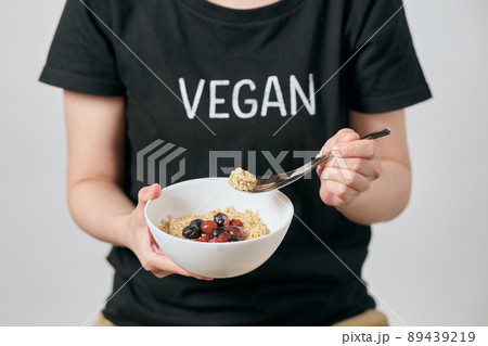 オートミールを食べる若いヴィーガン女性 オートミールを食べる若いヴィーガン女性 89439219