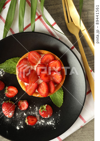 Concept of tasty food with strawberry tart on gray textured table Concept of tasty food with strawberry tart on gray textured table 89441561