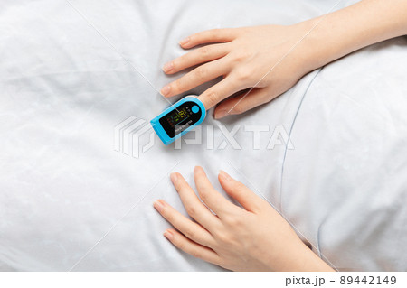 Hand of female patient with a pulse oximeter on the index finger, close-up. A hospitalized patient is in the hospital. Top view 89442149
