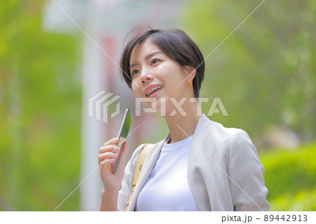 初夏の街_スマホを持つ女性_クローズアップ1 初夏の街_スマホを持つ女性_クローズアップ1 89442913