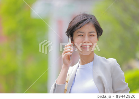 初夏の街_電話する女性_カメラ目線1 初夏の街_電話する女性_カメラ目線1 89442920