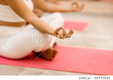 Girl does yoga. Young woman practices asanas on a beige one-ton background. 89443684