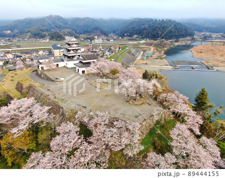 桜に囲まれた大洲城の天守閣と城壁の空撮 89444155