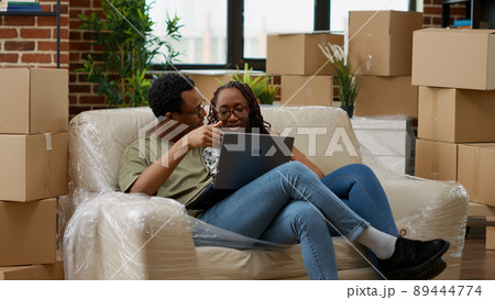 Man and woman buying furniture online on website to decorate new household property. Looking at interior decor inspiration on laptop to prepare apartment for new beginnings. Handheld shot. Man and woman buying furniture online on website to decorate new household property. Looking at interior decor inspiration on laptop to prepare apartment for new beginnings. Handheld shot. 89444774