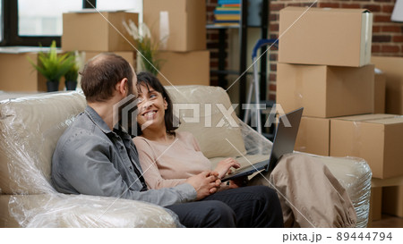 Young couple searching home decor inspiration on laptop doing online shopping to buy furniture and move in rented apartment flat. Decorating household space, using online website. 89444794