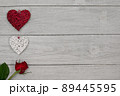 Valentine's Day background, white wooden planks with romantic red roses and red and white hearts. Modern vintage look for concepts, posters or design. 89445595