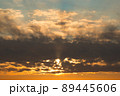 Orange sunset sky with rays of sun cloudscape. Dark fluffy clounds 89445606