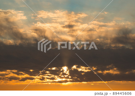 Orange sunset sky with rays of sun cloudscape. Dark fluffy clounds Orange sunset sky with rays of sun cloudscape. Dark fluffy clounds 89445606