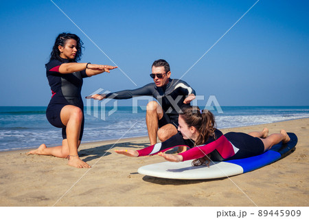 surf instructor and two girls beginner surfers on lesson in Goa India 89445909