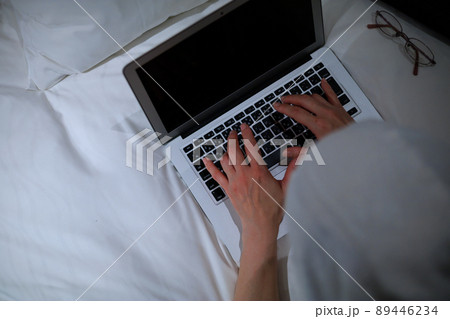 ホテルのベッドでノートパソコンを使用している女性	 89446234