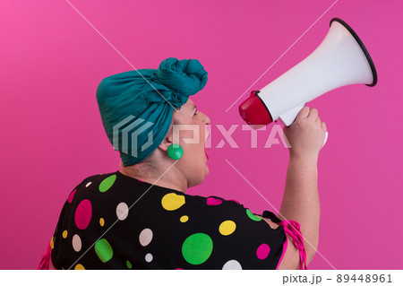 Funny plus size woman woman girl posing isolated on pastel pink wall background studio portrait. People sincere emotions lifestyle concept. Mock up copy space. Screaming in megaphone.  89448961