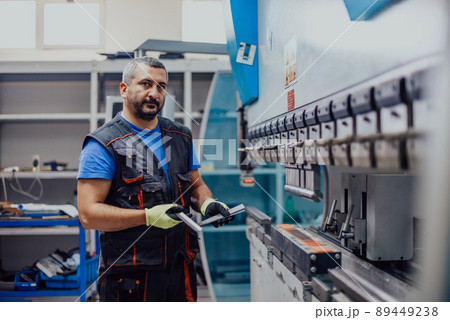 A smart factory worker or engineer makes machines in a production workshop. The concept of industry and engineering. Selective focus A smart factory worker or engineer makes machines in a production workshop. The concept of industry and engineering. Selective focus 89449238