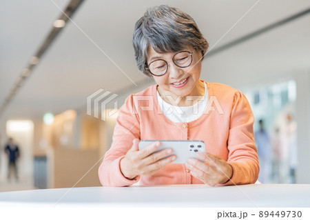 スマホで動画を見る眼鏡をかけたシニア女性　撮影協力「LINK FOREST] 89449730