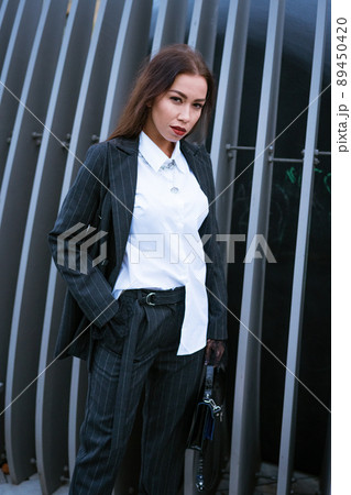 Beautiful business woman in a suit is posing 89450420
