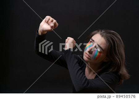Flag LGBT lizbian woman with rainbow tears on her cheek defends herself Flag LGBT lizbian woman with rainbow tears on her cheek defends herself 89450576