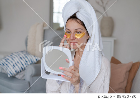Under concept eye treatment and body care. Beautiful caucasian woman applies 89450730