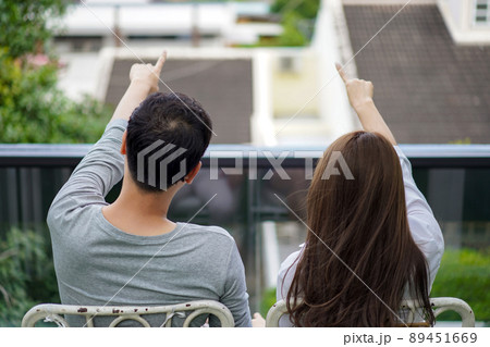 Asian couple lovers were sitting at the top of building rooftop and pointing to the future we want to be there. Asian couple lovers were sitting at the top of building rooftop and pointing to the future we want to be there. 89451669