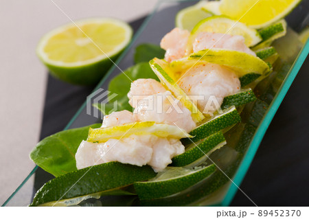 Ceviche from alaska pollock on a glass plate with lime and herbs 89452370
