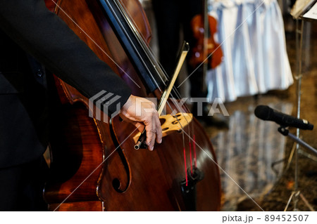 close up musician's hand is playing double bass in indoor event close up musician's hand is playing double bass in indoor event 89452507