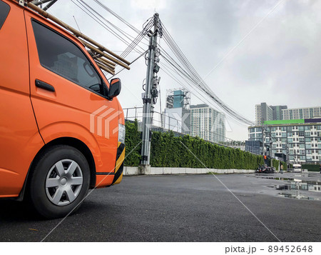 Private company electric orange van parking at the outdoor parking waiting for electric services. Private company electric orange van parking at the outdoor parking waiting for electric services. 89452648