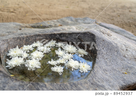 white flowers floating on the water in the big stone in the zen purple garden. 89452937