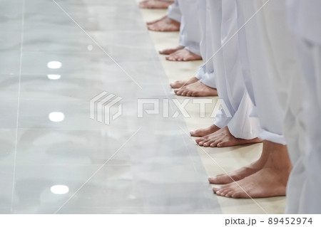 Asian men feet are standing in a row with all white trousers. 89452974