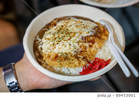 Tonkatsu; traditional Japanese food, crispy fried pork with sauces on top and rice under it, in the paper dish. Food street of Bangkok, Thailand. Tonkatsu; traditional Japanese food, crispy fried pork with sauces on top and rice under it, in the paper dish. Food street of Bangkok, Thailand. 89453001
