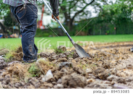 gardener digs the soil with his equipment for gardening and prepare land for plantation. 89453085