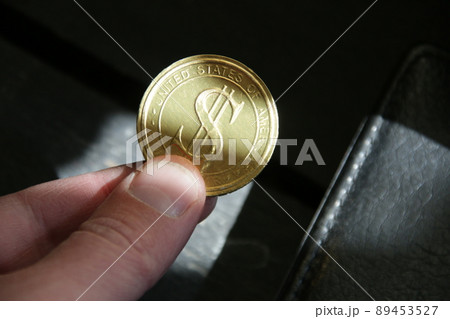 The hand holds a golden dollar coin. Successful business. 89453527