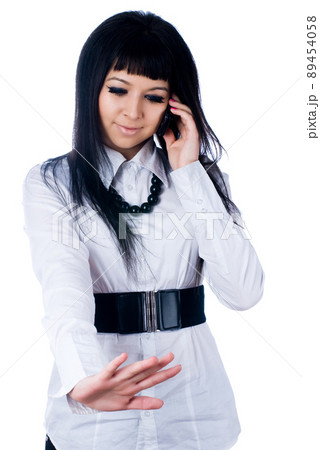 Young talking woman by mobile over white 89454058