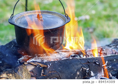 Camping kitchenware - pot on the fire at an outdoor campsite 89454309